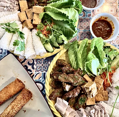 Share platter of grilled beef, fried tofu, sliced pork and woven rice vermicelli with lettuce, herbs and dipping sauces