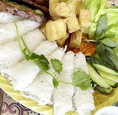 Woven rice vermicelli with grilled pork, fried tofu, lettuce and herbs, with dipping sauce