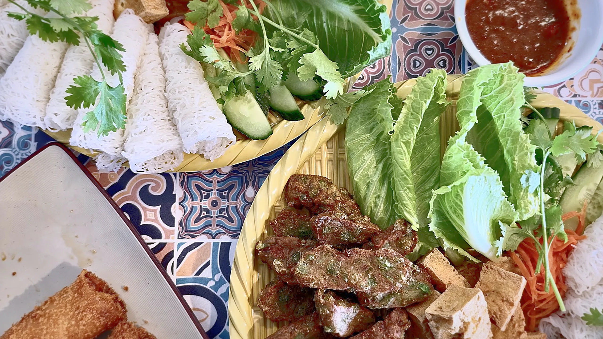 Share platter of grilled beef, fried tofu, sliced pork and woven rice vermicelli with lettuce, herbs and dipping sauces