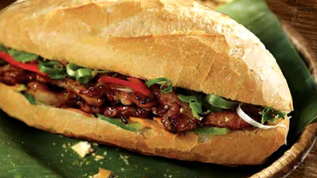 Vietnamese banh mi baguette filled with grilled pork, pickled vegetables and herbs